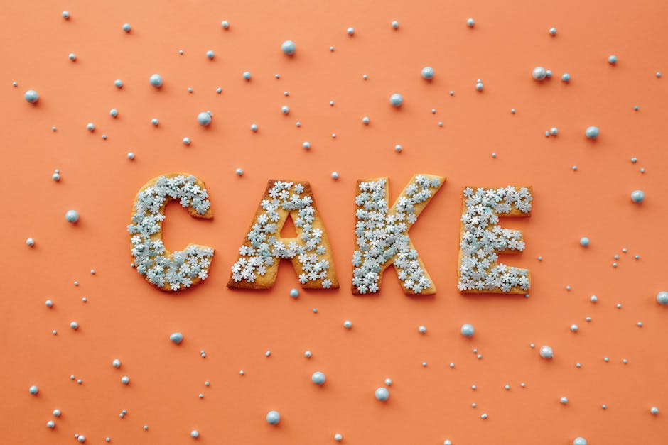 Flat lay of cake letters with sprinkles on orange background, perfect for celebrations.
